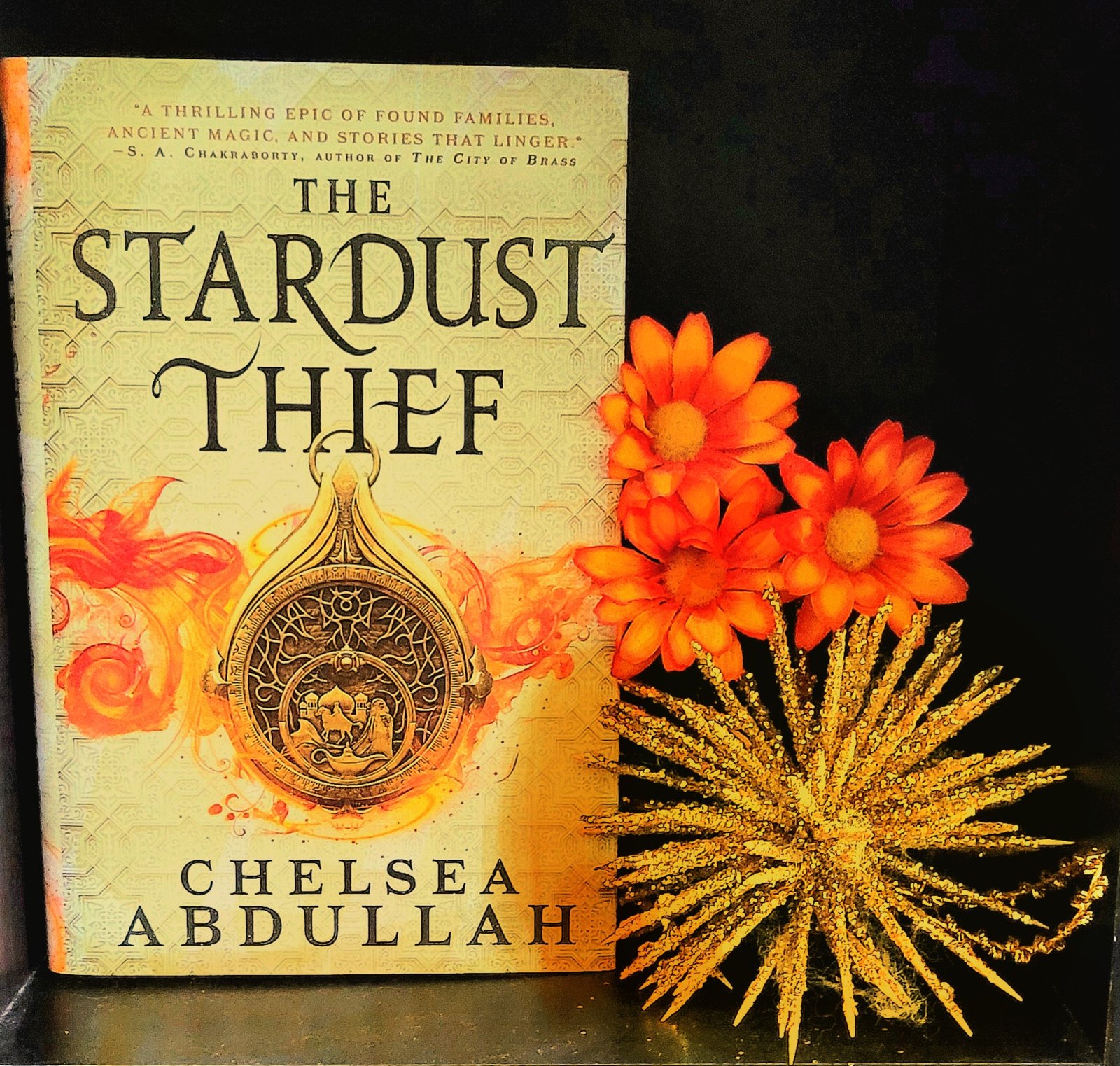 The Stardust Thief book, framed by flowers.